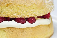 a cake with white frosting and raspberries on top