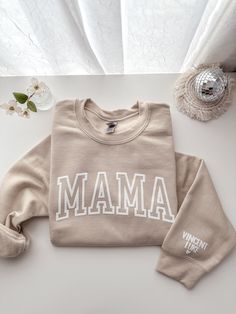 Personalized Mama Sweatshirt with Children's name on Sleeve COLOR:SAND Design is made with Puff Lettering Children's name on sleeve, the Heart is automatically added Celebrate motherhood in style with our personalized "MAMA" sweatshirt! Made from soft, high-quality fabric, this sweatshirt is as comfortable as it is stylish. Customize the sleeve with your children's name to create a one-of-a-kind piece that's perfect for you or as a thoughtful gift for a mom in your life. Key Features: Made from Sand Design, Teacher Accessories, Faith Clothing, Puff Print, Color Sand, Christmas Tumblers, Mama Sweatshirt, White Letters, Black Letter