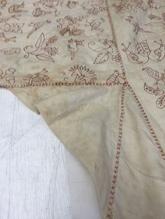 an old table cloth with embroidered designs on it