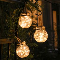 three light bulbs hanging from a tree with string lights attached to the outside of them