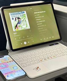 an open laptop computer sitting on top of a desk next to a cell phone and tablet