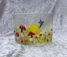 a glass bowl with mushrooms and flowers painted on it