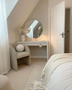 a bedroom with a white bed, vanity and mirror in the corner on the wall