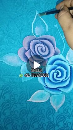 someone is painting a blue rose with watercolors