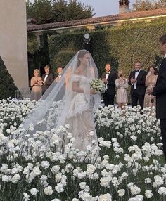 the bride and groom are standing in front of an outdoor ceremony with white flowers on the ground