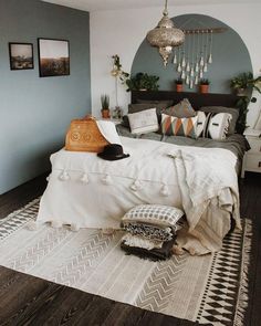 a bed room with a neatly made bed and pictures hanging on the wall above it