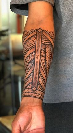 a man's arm with a tattoo on it and a cross in the middle