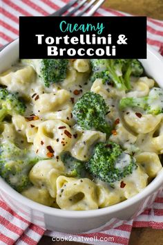 creamy tortellini and broccoli in a white bowl with a red checkered napkin