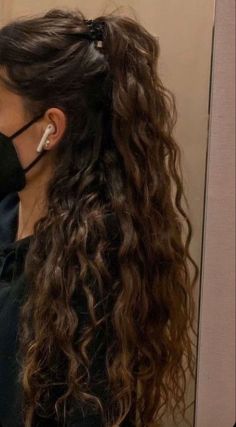 a woman wearing a face mask while brushing her hair