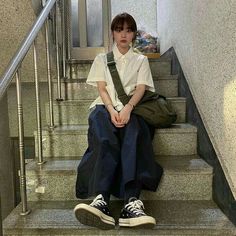 a person sitting on some stairs with their legs crossed