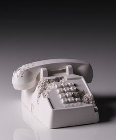 an old white telephone with some dirt on it