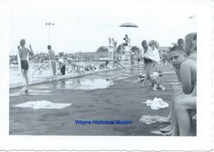 an old black and white photo of people playing in the water at a swimming pool