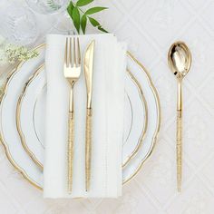 a white plate topped with goldware next to a silver fork and knife on top of a table