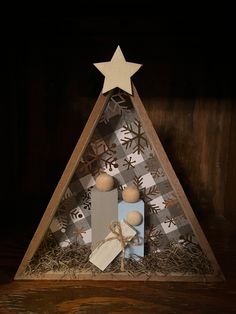 a christmas tree made out of wood and paper with decorations on it, including a star