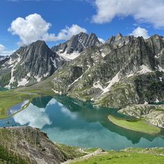 the mountains are covered in green grass and blue water, with small lakes surrounded by them