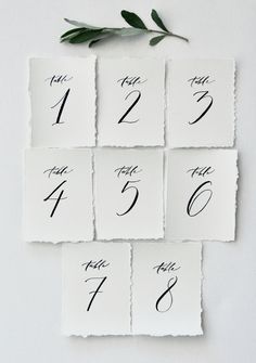 the table numbers are made out of white paper with black ink and green leaves on top