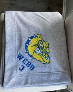 the university of west michigan logo is shown on a gray sweatshirt with blue and yellow letters