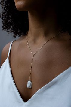 "A dainty Y-necklace with a large focal keshi pearl.  Dainty and unique, this wispy style gives a modern approach to a pearl necklace.  Lightweight and comfortable to wear.  Closure: spring ring Materials: 14K Gold Filled or Sterling Silver Measures approx. 18\" in length + 3 1/2\" drop Handmade in New York Arrives perfectly packaged, ready for gift-giving! Due to the nature of pearls, each pair will be slightly different, lending to a one of a kind design." White Lariat Pearl Necklace With Delicate Chain, Dainty White Lariat Necklace With Pearl Charm, Baroque Pearl Long Drop Wedding Jewelry, Minimalist White Lariat Necklace With Pearl Charm, Minimalist Baroque Pearl Necklace For Wedding, Minimalist White Lariat Necklace With Pearl Pendant, Delicate White Lariat Necklace With Pearl Charm, Baroque Pearl Drop Lariat Jewelry, Delicate Gold Pearl Lariat Necklace