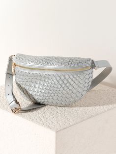 Give your handbag collection a stylish update with Shiraleah's Blythe Sling Bag. This sophisticated bag comes in a trendy and casual silhouette that can wrap around your waist or be slung fashionably across the body, and is made from woven vegan leather in a stylish, neutral silver color. With its adjustable belt strap and front-zip pocket, it allows you to go hands-free for all your daily activities. Pair with matching styles in the Blythe Collection, or other items from Shiraleah to complete y Chic Rectangular Belt Bag With Zipper, Chic Shoulder Belt Bag With Zipper, Trendy Woven Leather Shoulder Bag, Chic Rectangular Belt Bag With Zipper Closure, Chic Belt Bag With Zipper Closure, Chic Pouch Belt Bag With Zipper, Chic Pouch Belt Bag With Zipper Closure, Trendy Woven Clutch Shoulder Bag, Trendy Woven Crossbody Bag