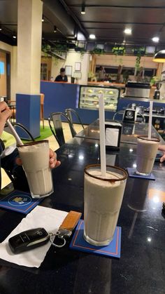 two people sitting at a table with drinks in front of them