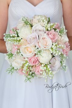 a bride holding a bouquet of white and pink flowers