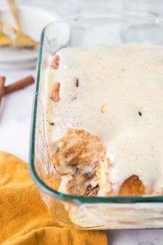 a glass casserole dish filled with food on top of a white tablecloth