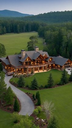 an aerial view of a large house in the middle of a green field with trees