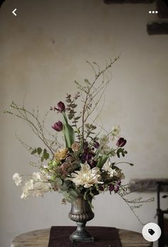 a vase filled with flowers sitting on top of a wooden table