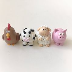 five small plastic farm animals sitting next to each other on a white surface with one pig, the other sheep and two chickens