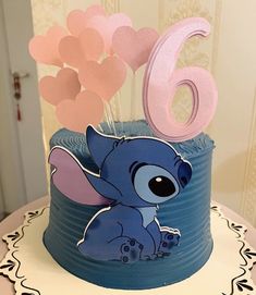 a birthday cake with the number six on it and an elephant figurine sitting in front of it