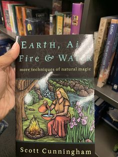 a person holding up a book about fire and water