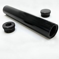 an image of a black pipe and fittings on a white table top with space for text