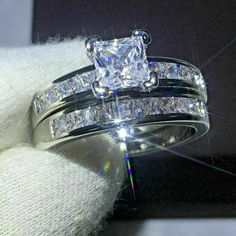 a close up of a diamond ring on top of a white glove with the light shining through it