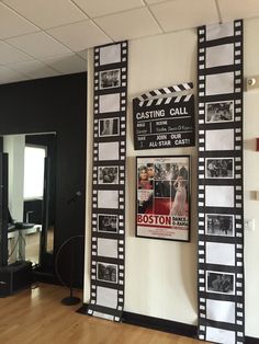 a movie poster is hanging on the wall next to a wooden floor in an empty room