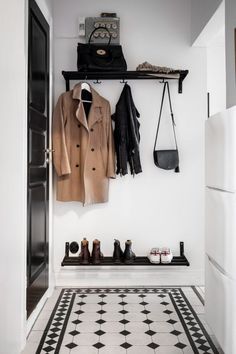 a coat rack with coats and shoes hanging on it