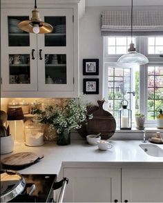 a kitchen filled with lots of white counter top space next to a large open window