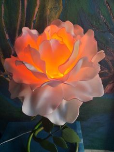 a large pink flower sitting on top of a table