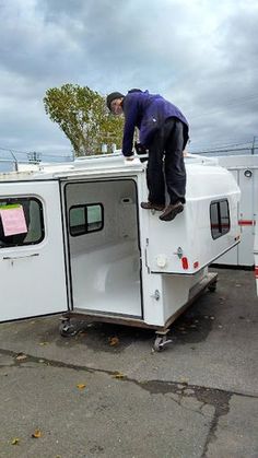 a man standing on top of a white trailer