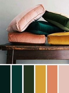 pillows and blankets on top of a wooden table with color swatches in the background