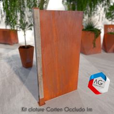 an open book sitting on top of a wooden table next to potted planters