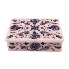 a white box with blue flowers and leaves on the inside, sitting on a white surface