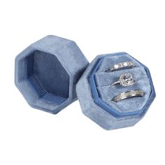 two wedding rings in a blue velvet ring box with diamond accents on the sides and inside