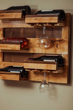 a wooden wine rack with several bottles and glasses hanging from it's sides on the wall