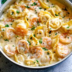 a bowl filled with pasta and shrimp on top of a table