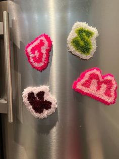 four pieces of crocheted fabric are arranged on the side of a stainless steel refrigerator