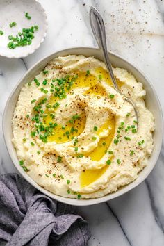 a bowl filled with mashed potatoes topped with green onions