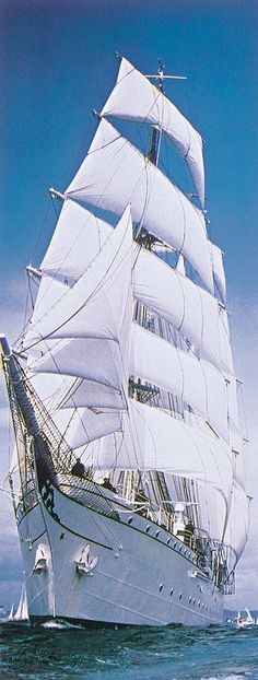 a large white sail boat sailing in the ocean