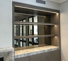 an empty room with marble counter tops and shelves