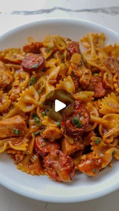 a white plate topped with pasta and meat