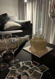 a table topped with wine glasses and a cake covered in frosting next to pictures